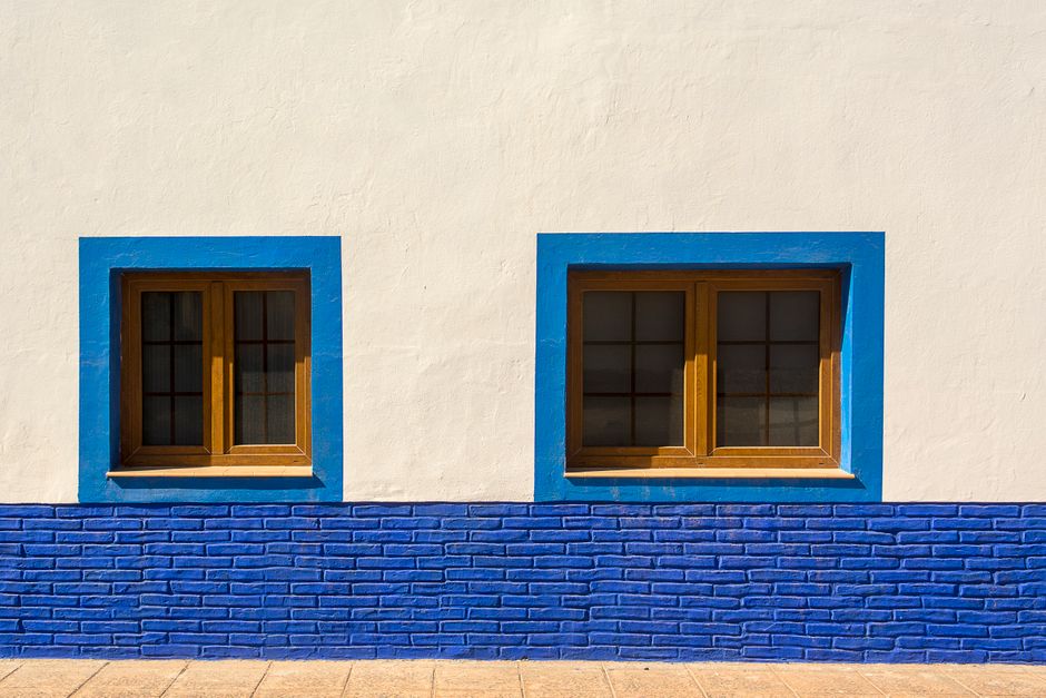 Blue-framed windows on a white painted wall.
