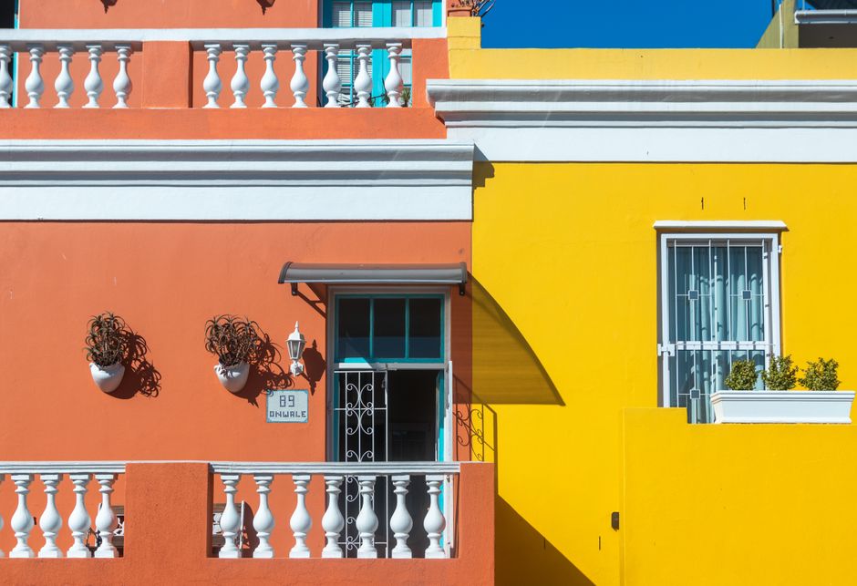 Colorful buildings in the a row of houses with orange and yellow painted facades.