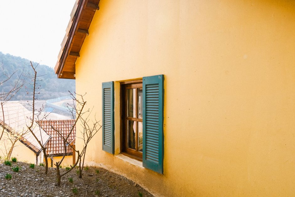 A yellow house with blue shutters.