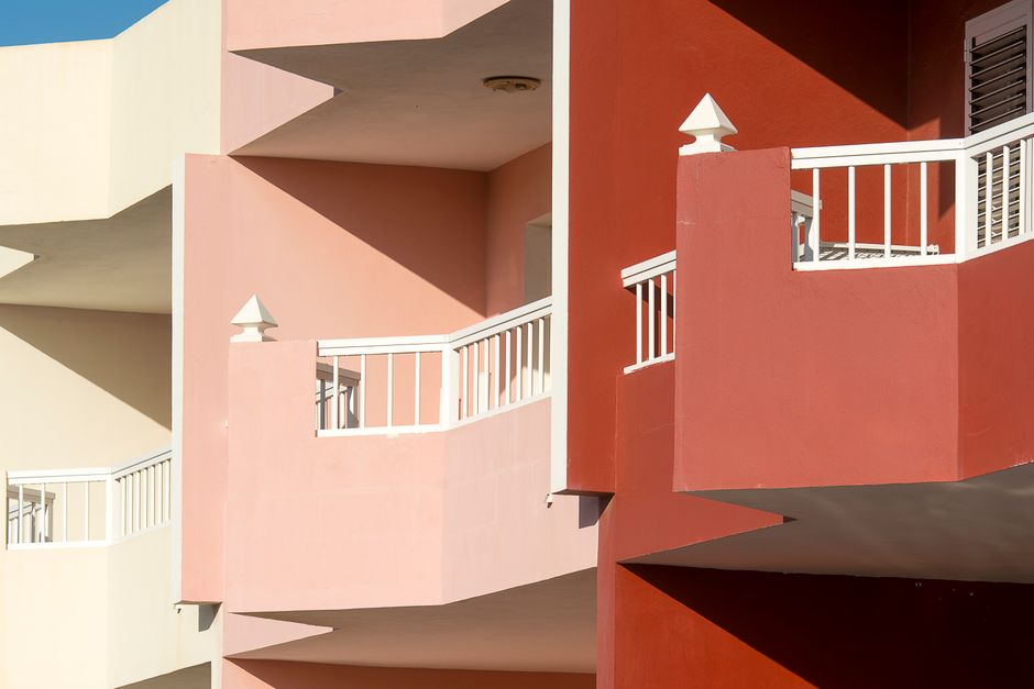 Painted house walls with balconies in several colours.