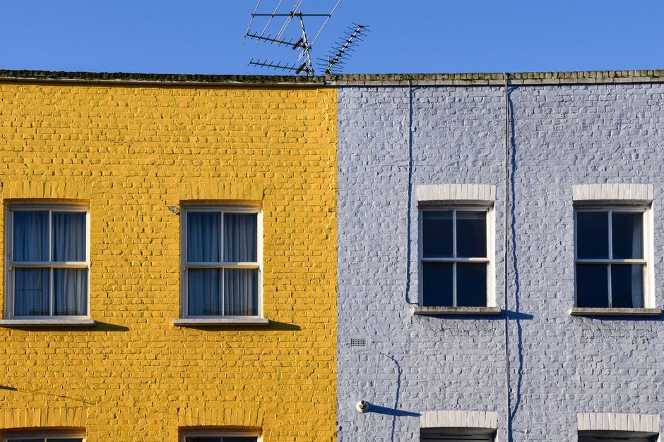 Vibrant yellow and blue townhouses with yellow and blue painted facades.